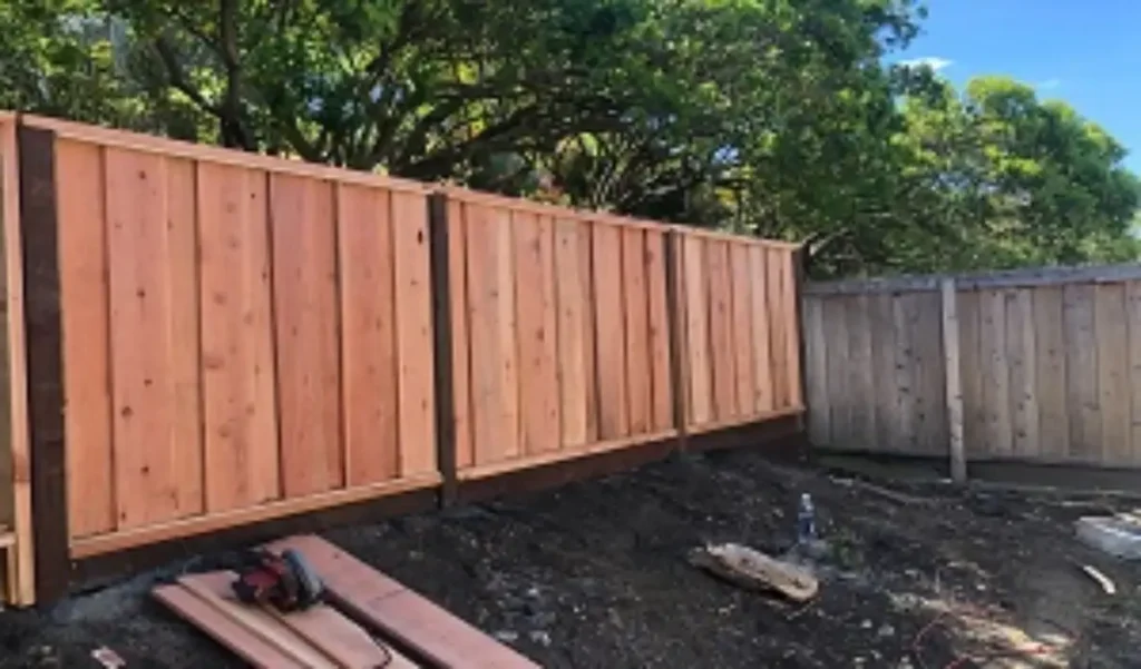 Fence replacement in progress, with professionals removing old panels and installing new, durable fencing to enhance security and curb appeal