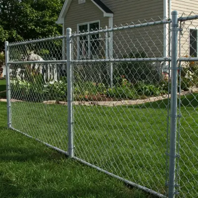 Chain link fence enclosing a residential yard, offering affordable security and visibility with a galvanized steel finish