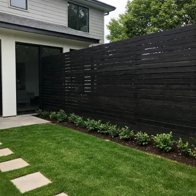 Fence with black horizontal slats providing sleek, modern privacy and a bold architectural touch to a contemporary backyard