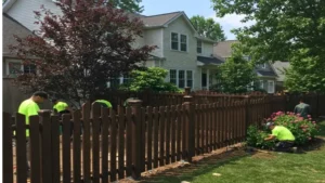 Installing fence around residential property, with a team securing posts and panels to define boundaries and enhance privacy