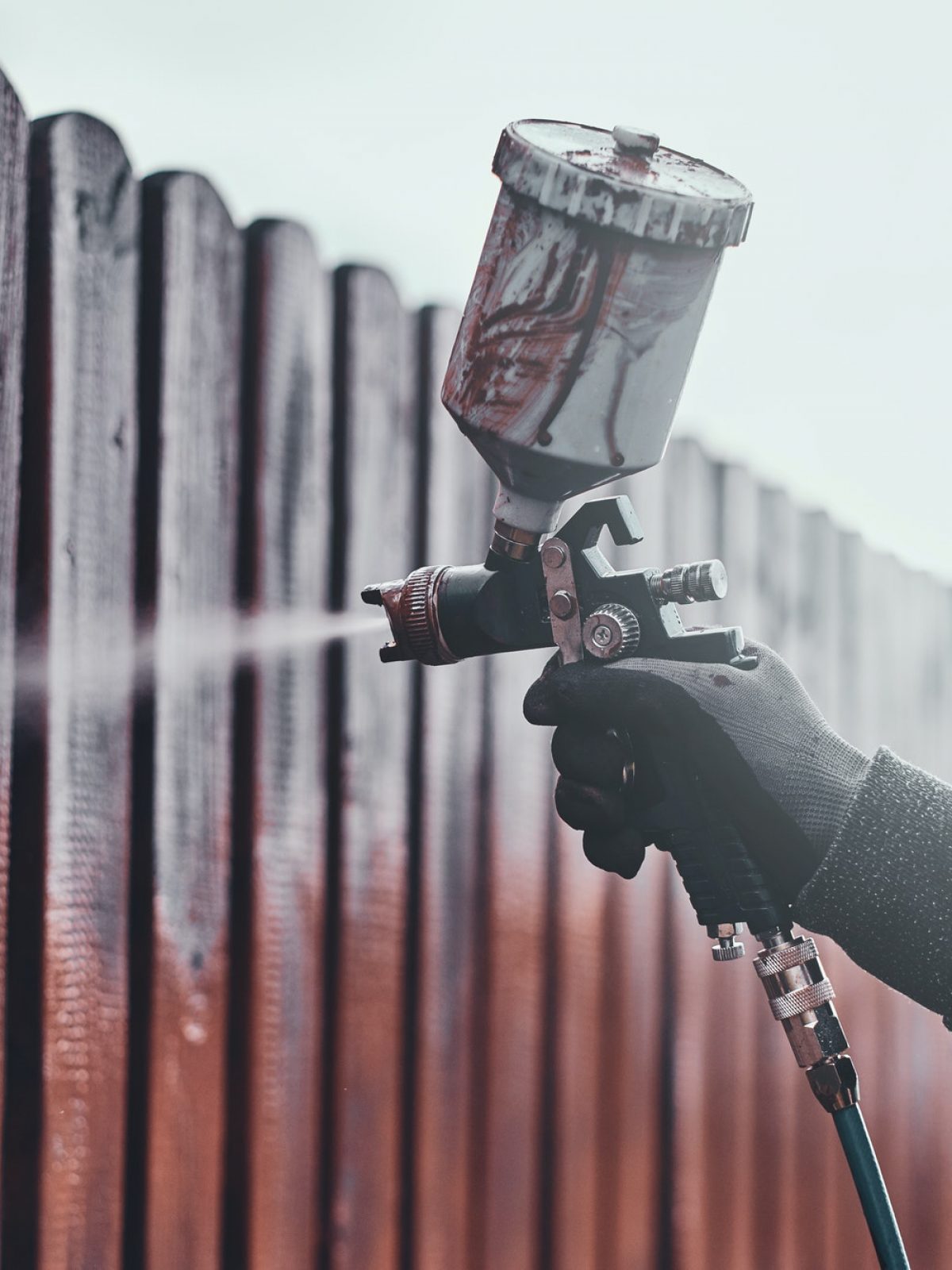Diligent working is applying colour to the fence with airbrush